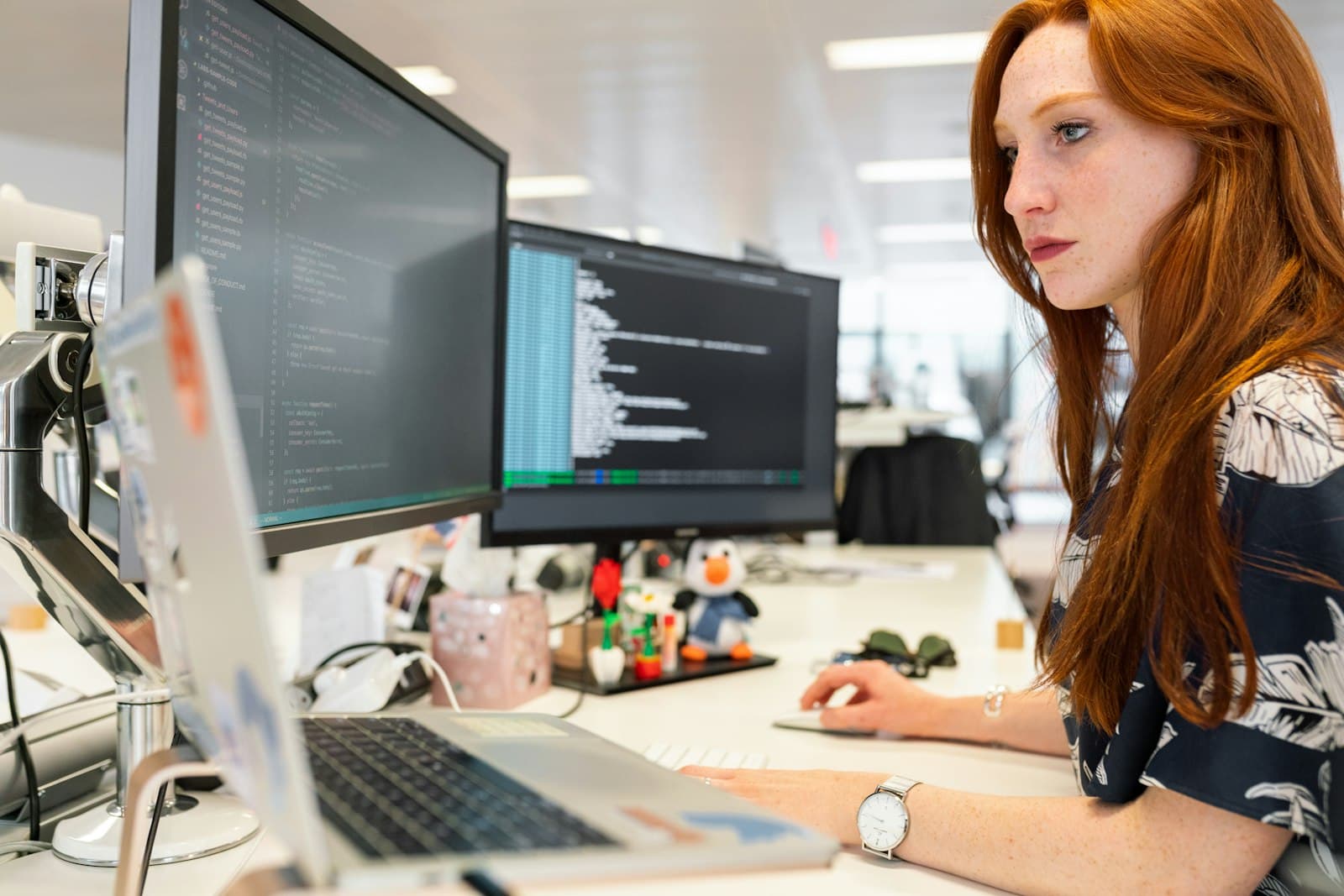 A software engineer focused on code across two monitors